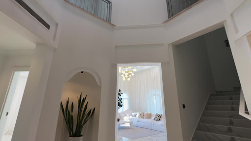 Modern apartment interior at ELO 3 featuring elegant living room, plant decor, and marble staircase.